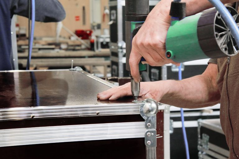 A Booth Junkie technician riveting a replacement touchscreen into a photo booth flight case frame
